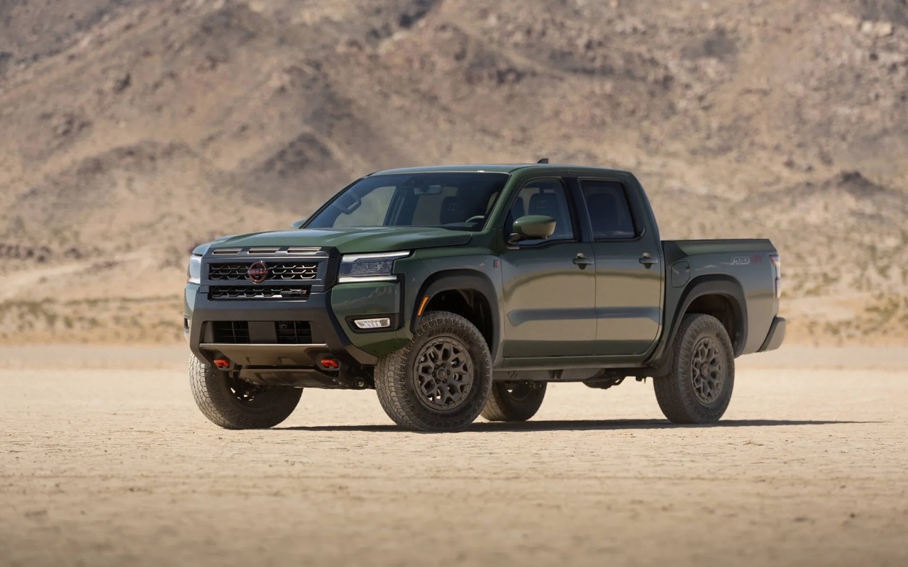 Pick-up Nissan Frontier 2026 vert en vue trois quarts avant, stationné dans un désert montagneux sous un ciel clair.